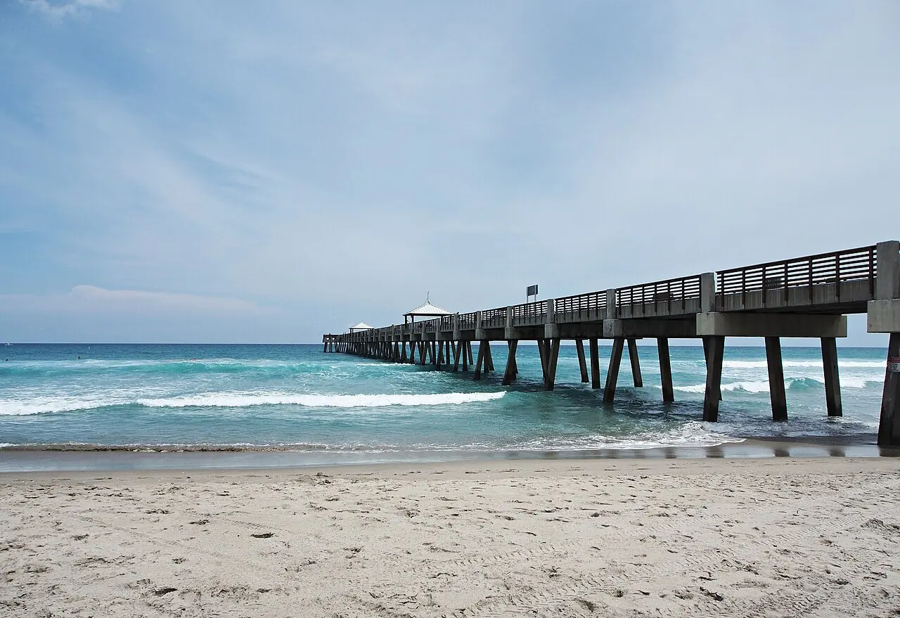 Beach pier extending into the Atlantic on a clear Florida day